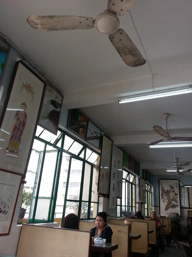 靠窗的一邊都是木卡位,放置了一些小花盤,更有懷舊的吊風扇