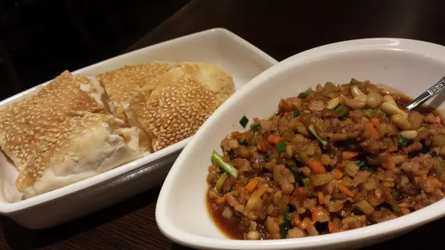 將松子雞粒填滿旁邊的包裡面進食，吃不完可用作配白飯享用