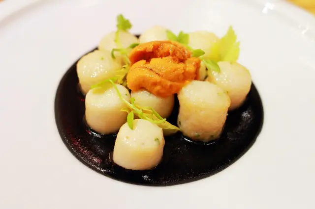Home-made scallops gnocchi on a layer of black ink sauce with sea urchins and celery shoots 帶子粉糰配墨魚汁