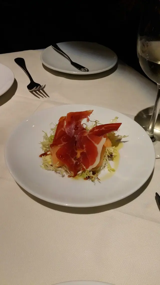 Iberico數片紅潤透亮，輕置於粉橙的哈蜜瓜塊之上