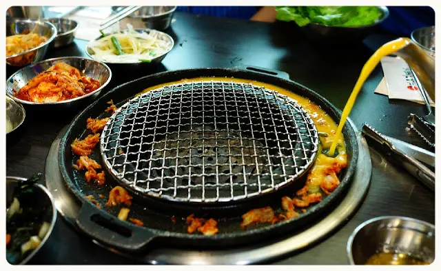 店員放入泡菜粒, 倒入蛋漿於爐邊慢慢煮熟, 這種食法新穎又有趣