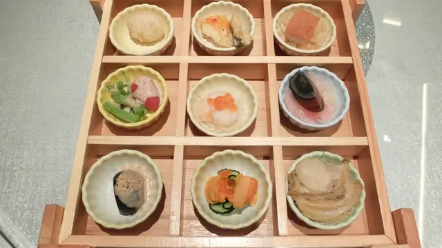 九款包括:北海道馬糞海膽 、海鮮蕃茄盒伴冰菜、 清酒鮑魚、 胡麻醬無花果、 子薑皮蛋、 酥炸白鴿蛋、 香煎墨魚餅、 脆皮燒腩仔及 柚子蝦。