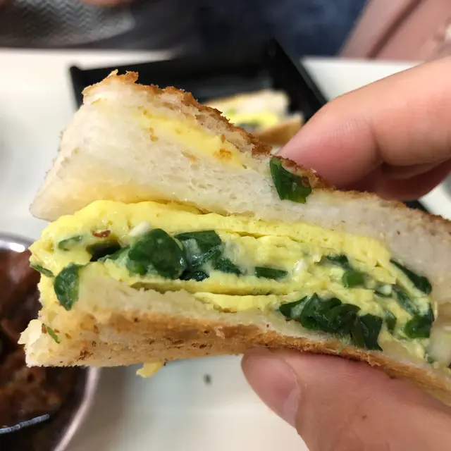 一碟總共分為三件,細心睇,原來一件蔥花蛋治係有四部份組成,抵免各有一塊搽上牛油嘅超薄多士,中間夾有一塊白方包,及主角蔥花炒蛋。一啖咬落蔥花味濃郁,喜愛食蔥嘅朋友一定唔可以錯過,另外多士夾嘅方包又是另一種有趣口感