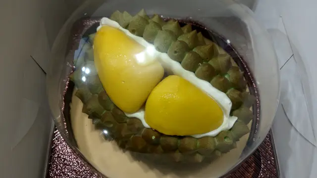 蛋糕用上一個半球形透明蓋保護，同時可掩蓋濃郁榴槤香氣