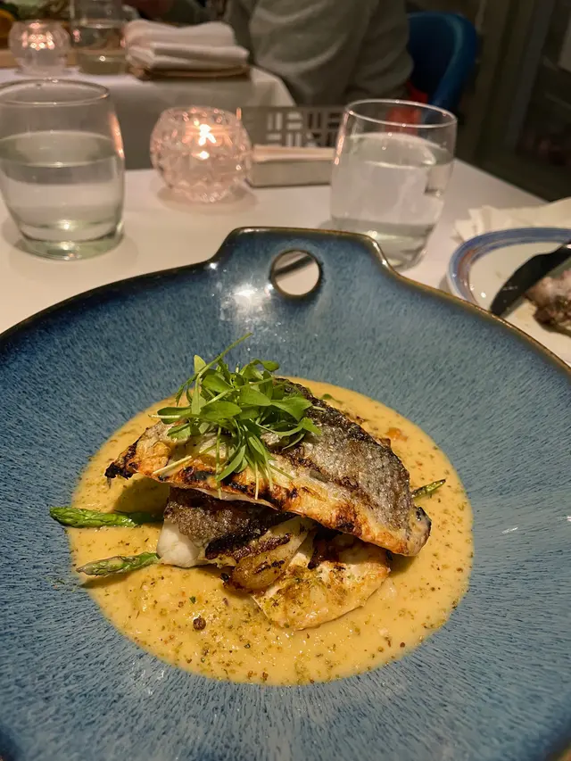 Oven baked Seabass with roasted cauliflower puree and grill baby asparagus and sea urchin and olive sauce