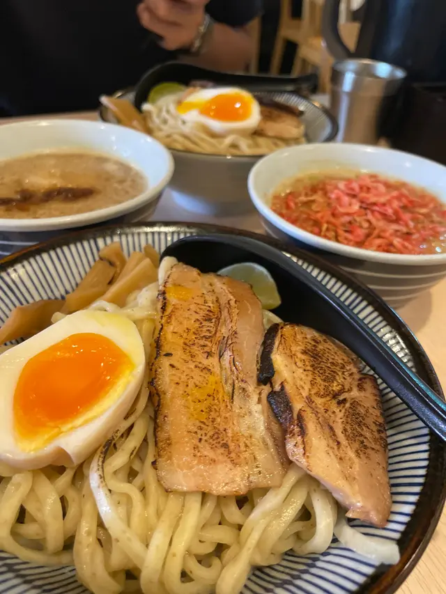 呢間拉麵店以雪糕拉麵聞名🍦 閒日下晝去都幾多人 排左一陣先入到去🤡 店面比較小 佢地擺櫈的方式挺搞笑 會將櫈腳放在臺腳上 每次客人搬開張櫈時都會好大聲🥸 比起其他鋪頭呢度的沾麵相對冇咁膩👍🏻 不過表現也是不過不失~ 可能食慣左日本嗰啲返唔到轉頭🤥🤭 海老沾麵($88) 湯頭的蝦味蠻濃郁的🦐 但又不會太鹹太油膩 表面鋪滿了小蝦乾 脆脆的 增加層次感✨ 麵條除咗有得撰軟硬度 仲可以撰凍定熱上 個人認為凍上更能保持口感 配上熱辣辣的湯頭 冷熱交錯 挺特別的🥰 麵條有淡淡的小麥味