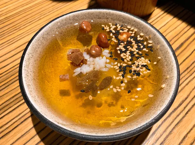 冰粉似是透明啫喱，口感嫩滑，
面頭撒上花生、黑白芝麻、山楂、酒釀、提子乾等，
拌勻後充滿咸香味又帶微甜，味道清新，
質感Q彈清爽，口感極佳富層次，解辣一流！
