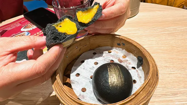 黑色拼金色的賣相型格，
包皮鬆軟有彈性，
趁熱打開時，還有滿滿的鹹蛋黃及流沙奶黃，甜而不膩，香濃可口～